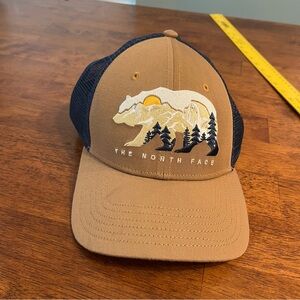 The North Face Tan and Navy Trucker Hat bear one size